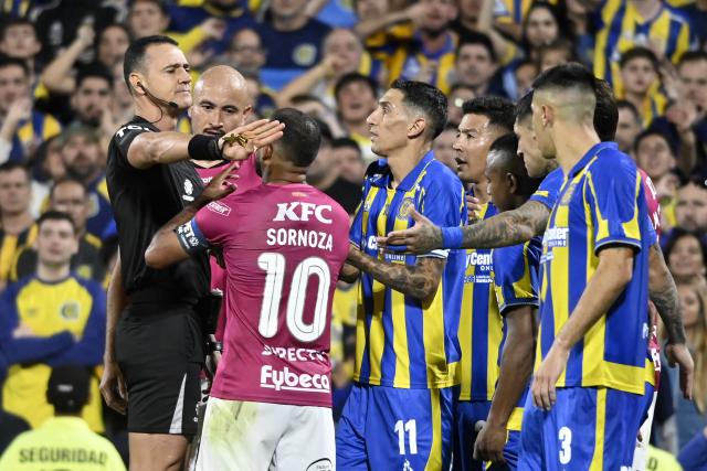 Colombian referee Wilmar Roldan gestures before showing a red card to Independiente del Valle's midfielder #10 Junior Sornoza during the Copa Libertadores group stage football match between Argentina's Rosario Central and Ecuador's Independiente del Valle at the Gigante de Arroyito stadium in Rosario, Santa Fe province, Argentina, on April 9, 2026. (Photo by Marcelo Manera / AFP)