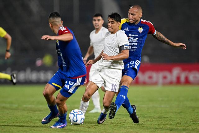 Libertad's forward #10 Lorenzo Melgarejo and Universidad Central's defender #05 Luis Martinez fight for the ball during the Copa Libertadores group stage football match between Venezuela's Universidad Central and Paraguay's Libertad at the Olimpico de la UCV stadium in Caracas, on April 9, 2026. (Photo by Juan BARRETO / AFP)