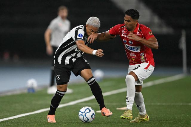 Botafogo's Colombian midfielder #14 Jordan Barrera and Caracas' defender #13 Jesus Yendis fight for the ball during the Copa Sudamericana group stage football match between Brazil's Botafogo and Venezuela's Caracas FC at the Nilton Santos stadium in Rio de Janeiro, Brazil, on April 9, 2026. (Photo by MAURO PIMENTEL / AFP)