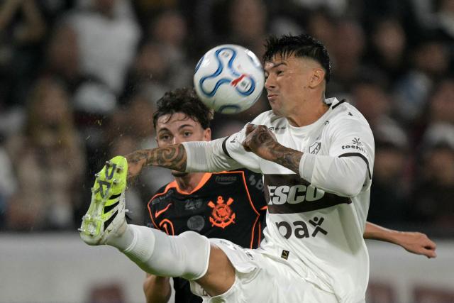 Platense's defender #31 Victor Cuesta AND Corinthians' midfielder #07 Breno Bidon fight for the ball during the Copa Libertadores group stage football match between Argentina's Platense and Brazil's Corinthians at the Ciudad de Vicente Lopez stadium in Vicente Lopez, Buenos Aires province, Argentina, on April 9, 2026. (Photo by JUAN MABROMATA / AFP)