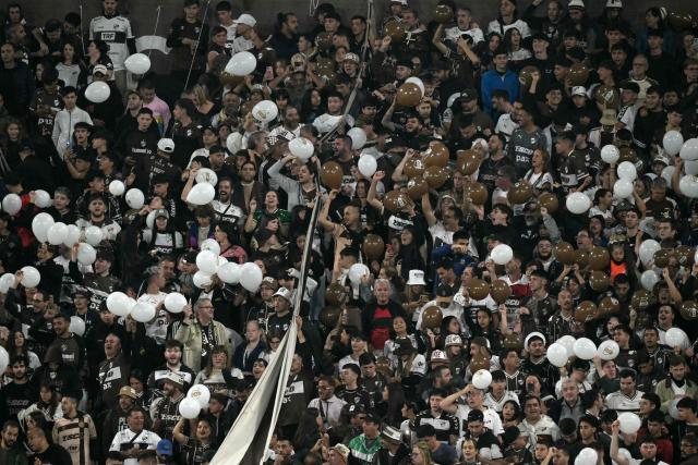 Fans of Platense cheer for their team during the Copa Libertadores group stage football match between Argentina's Platense and Brazil's Corinthians at the Ciudad de Vicente Lopez stadium in Vicente Lopez, Buenos Aires province, Argentina, on April 9, 2026. (Photo by JUAN MABROMATA / AFP)