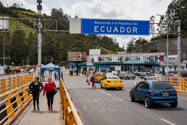 (FILES) Vehicles and people cross the Rumichaca International Bridge on the Colombia–Ecuador border, in Ipiales, Narino department, Colombia, on January 21, 2026. Ecuador will raise tariffs on imports from Colombia from 50% to 100% starting in May 2026, a move that Colombian President Gustavo Petro called a "monstrosity" amid a diplomatic crisis between the two neighboring countries. (Photo by Reicarmyr CANIZARES / AFP)