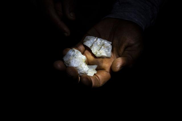 (FILES) A Venezuelan miner shows rocks with traces of gold found in a mine to later be processed by hand in a mill in El Callao, Bolivar State, Venezuela, on August 27, 2023. Venezuela's Parliament approved a mining law that opens the door for foreign investors to exploit the country's vast reserves on April 9, 2026, following a similar move regarding the oil industry under pressure from the United States. (Photo by Magda Gibelli / AFP)