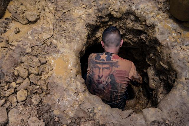 (FILES) A Venezuelan miner wearing a shirt with the image of "Uncle Sam" works digging in a mine to extract gold, which will then be sold in El Callao, Bolivar State, Venezuela, on August 29, 2023. Venezuela's Parliament approved a mining law that opens the door for foreign investors to exploit the country's vast reserves on April 9, 2026, following a similar move regarding the oil industry under pressure from the United States. (Photo by Magda Gibelli / AFP)