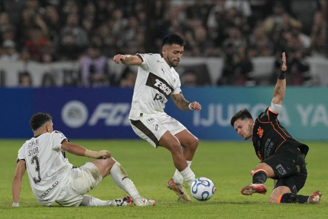 Platense's midfielder #15 Franco Amarfil and Corinthians' Argentine midfielder #08 Rodrigo Garro fight for the ball next to Platense's defender #03 Tomas Silva during the Copa Libertadores group stage football match between Argentina's Platense and Brazil's Corinthians at the Ciudad de Vicente Lopez stadium in Vicente Lopez, Buenos Aires province, Argentina, on April 9, 2026. (Photo by JUAN MABROMATA / AFP)