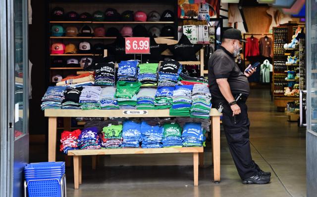 A vendor at a shop selling t-shirts awaits customers in Hollywood, California on April 9, 2026. US personal income unexpectedly declined in February, while a key inflation gauge rose in line with estimates, according to government data released on April 9. The report largely pre-dates the Middle East war that analysts expect to dramatically impact the March figures. (Photo by Frederic J. BROWN / AFP)