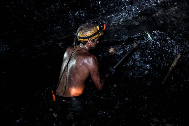 (FILES) A miner works to extract coal from the Los Parras mine in Lobatera, Tachira state, Venezuela, on March 3, 2022. Venezuela's Parliament approved a mining law that opens the door for foreign investors to exploit the country's vast reserves on April 9, 2026, following a similar move regarding the oil industry under pressure from the United States. (Photo by Johnny PARRA / AFP)