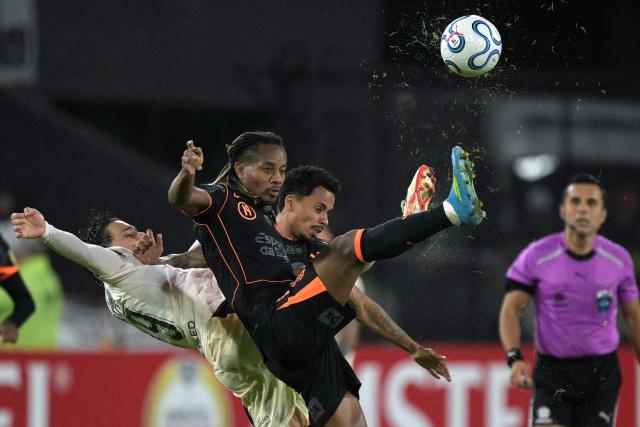 Platense's forward #99 Gonzalo Lencina and Corinthians' Peruvian forward #19 Andre Carrillo fight for the ball during the Copa Libertadores group stage football match between Argentina's Platense and Brazil's Corinthians at the Ciudad de Vicente Lopez stadium in Vicente Lopez, Buenos Aires province, Argentina, on April 9, 2026. (Photo by JUAN MABROMATA / AFP)