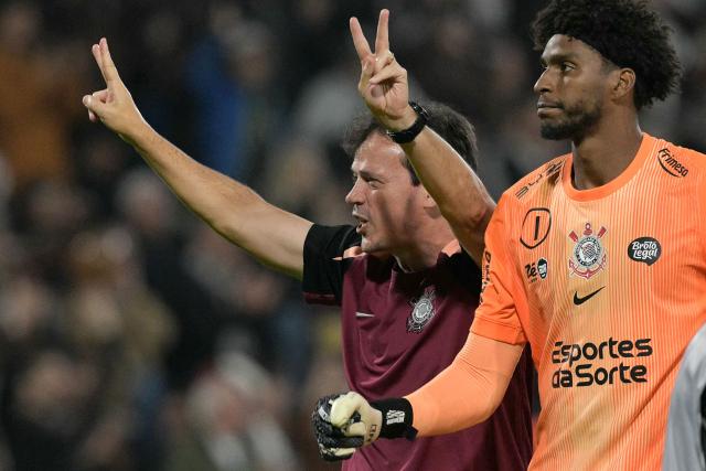 Corinthians' head coach Fernando Diniz (L) and goalkeeper #01 Hugo Souza celebrate after winning the Copa Libertadores group stage football match between Argentina's Platense and Brazil's Corinthians at the Ciudad de Vicente Lopez stadium in Vicente Lopez, Buenos Aires province, Argentina, on April 9, 2026. (Photo by JUAN MABROMATA / AFP)