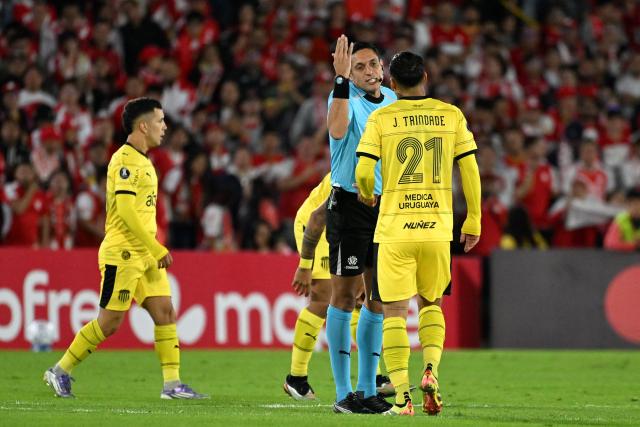 Venezuelan referee Jesus Valenzuela talks to Penarol's midfielder #21 Jesus Trindade during the Copa Libertadores group stage football match between Colombia's Independiente Santa Fe and Uruguay's Penarol at the Nemesio Camacho El Campin stadium in Bogota, on April 9, 2026. (Photo by Luis ACOSTA / AFP)
