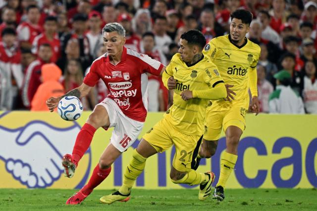Santa Fe's midfielder #16 Daniel Torres and Penarol's midfielder #21 Jesus Trindade fight for the ball during the Copa Libertadores group stage football match between Colombia's Independiente Santa Fe and Uruguay's Penarol at the Nemesio Camacho El Campin stadium in Bogota, on April 9, 2026. (Photo by Luis ACOSTA / AFP)