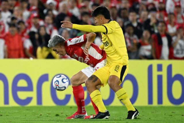 Santa Fe's midfielder #16 Daniel Torres (L) and Penarol's midfielder #08 Roberto Fernandez (R) fight for the ball during the Copa Libertadores group stage football match between Colombia's Independiente Santa Fe and Uruguay's Penarol at the Nemesio Camacho El Campin stadium in Bogota, on April 9, 2026. (Photo by Luis ACOSTA / AFP)