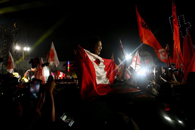 Peru's presidential candidate Keiko Fujimori, for the Fuerza Popular party, holds a national flag during her closing campaign rally at Villa el Salvador in Lima on April 9, 2026. Peru will hold presidential elections on April 12. (Photo by ERNESTO BENAVIDES / AFP)