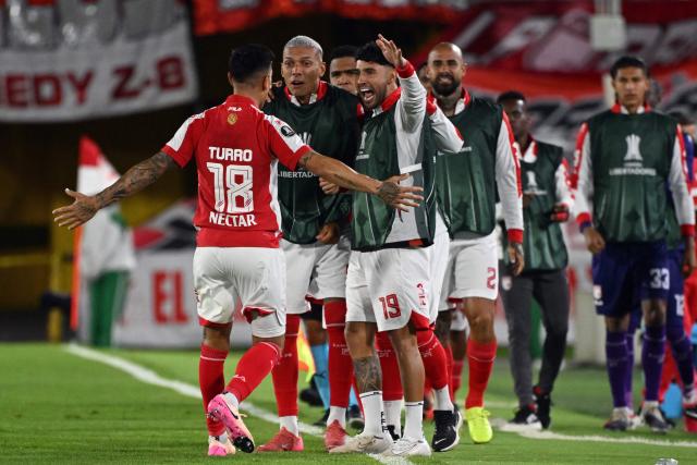 Santa Fe's Argentine defender #18 Emanuel Olivera celebrates with teammates after scoring his team's first goal during the Copa Libertadores group stage football match between Colombia's Independiente Santa Fe and Uruguay's Penarol at the Nemesio Camacho El Campin stadium in Bogota, on April 9, 2026. (Photo by Luis ACOSTA / AFP)