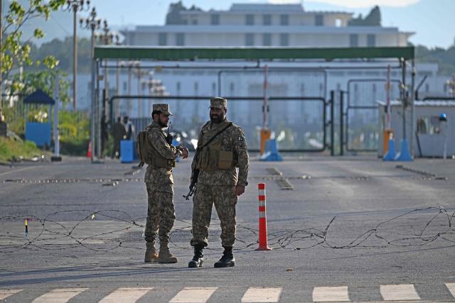 Pakistani soldiers stand guard near the President House in the Red Zone area in Islamabad on April 10, 2026. Pakistan has been preparing for high-stakes talks involving US and Iranian representatives over the war in the Middle East, with the White House saying Vice President JD Vance will be leading a team to the negotiations in Islamabad "this weekend". (Photo by Aamir QURESHI / AFP)