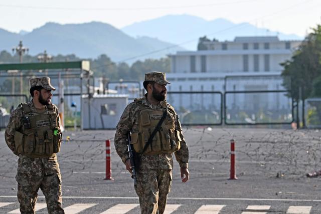 Pakistani soldiers stand guard near the President House in the Red Zone area in Islamabad on April 10, 2026. Pakistan has been preparing for high-stakes talks involving US and Iranian representatives over the war in the Middle East, with the White House saying Vice President JD Vance will be leading a team to the negotiations in Islamabad "this weekend". (Photo by Aamir QURESHI / AFP)