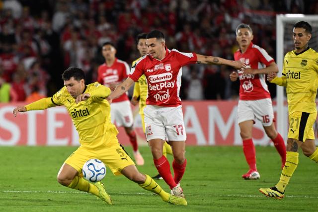 Penarol's Argentine midfielder #05 Eric Remedi and Santa Fe's forward #17 Maximiliano Lovera fight for the ball during the Copa Libertadores group stage football match between Colombia's Independiente Santa Fe and Uruguay's Penarol at the Nemesio Camacho El Campin stadium in Bogota, on April 9, 2026. (Photo by Luis ACOSTA / AFP)