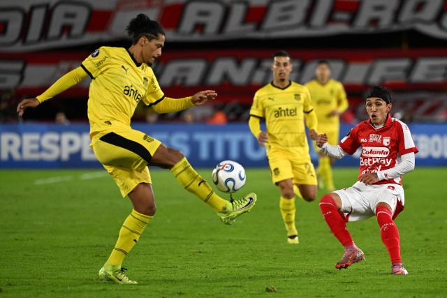 Penarol's defender #03 Mauricio Lemos (L) controls the ball past Santa Fe's forward #08 Omar Fernandez Frasica (R) during the Copa Libertadores group stage football match between Colombia's Independiente Santa Fe and Uruguay's Penarol at the Nemesio Camacho El Campin stadium in Bogota, on April 9, 2026. (Photo by Luis ACOSTA / AFP)