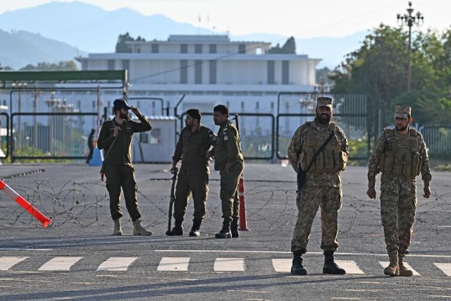 Pakistani soldiers and police officers stand guard near the President House in the Red Zone area in Islamabad on April 10, 2026. Pakistan has been preparing for high-stakes talks involving US and Iranian representatives over the war in the Middle East, with the White House saying Vice President JD Vance will be leading a team to the negotiations in Islamabad "this weekend". (Photo by Aamir QURESHI / AFP)