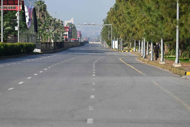 People walk along a closed street in the Red Zone area in Islamabad on April 10, 2026. Pakistan has been preparing for high-stakes talks involving US and Iranian representatives over the war in the Middle East, with the White House saying Vice President JD Vance will be leading a team to the negotiations in Islamabad "this weekend". (Photo by Aamir QURESHI / AFP)