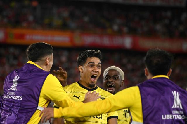 Penarol's forward #19 Matias Arezo celebrates with teammates after scoring his team's first goal during the Copa Libertadores group stage football match between Colombia's Independiente Santa Fe and Uruguay's Penarol at the Nemesio Camacho El Campin stadium in Bogota, on April 9, 2026. (Photo by Luis ACOSTA / AFP)