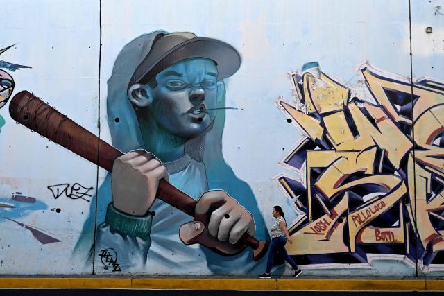 A man walks past a mural painted by graffiti artists on Las Amapolas Avenue in San Salvador on March 9, 2026. (Photo by Marvin RECINOS / AFP)