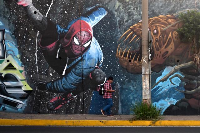 A man walks past a Spider-Man mural painted by graffiti artists on Las Amapolas Avenue in San Salvador on March 9, 2026. (Photo by Marvin RECINOS / AFP)