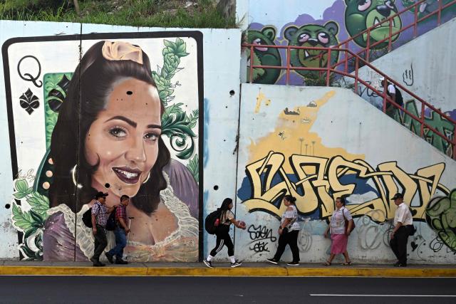 People walk past a mural painted by graffiti artists on Las Amapolas Avenue in San Salvador on March 9, 2026. (Photo by Marvin RECINOS / AFP)