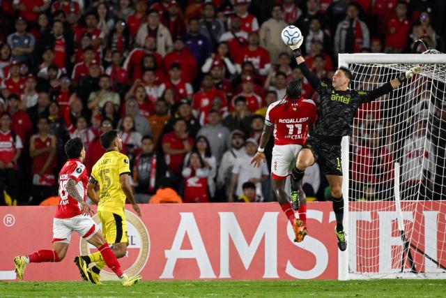 Penarol's goalkeeper #01 Sebastian Britos (R) makes a save past Santa Fe's forward #11 Hugo Rodallega during the Copa Libertadores group stage football match between Colombia's Independiente Santa Fe and Uruguay's Penarol at the Nemesio Camacho El Campin stadium in Bogota, on April 9, 2026. (Photo by Luis ACOSTA / AFP)