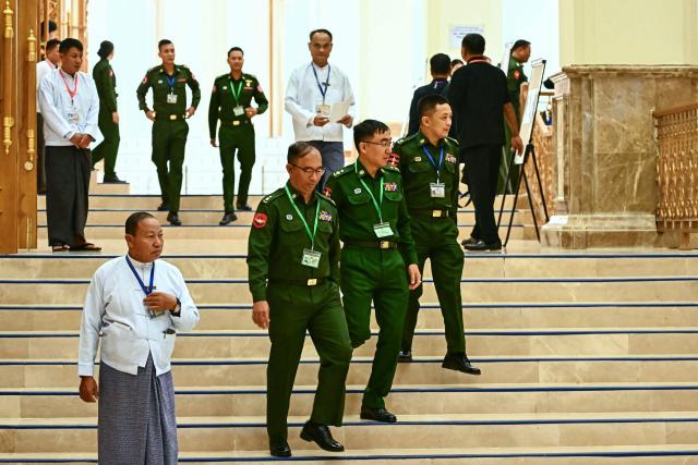 Military officers serving as members of Myanmar's parliament arrive to attend the sworn-in ceremony for Myanmar president during a session of the Pyidaungsu Hluttaw (Union Parliament) in Naypyidaw on April 10, 2026. Myanmar junta chief Min Aung Hlaing was sworn in as president on April 10, 2026, AFP journalists saw, continuing his rule from a civilian post five years after snatching power in a coup. (Photo by Sai Aung MAIN / AFP)