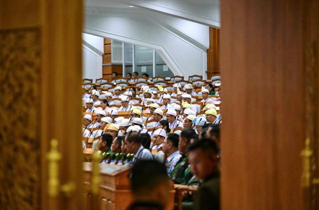 Members of Myanmar's parliament attend the sworn-in ceremony for Myanmar president during a session of the Pyidaungsu Hluttaw (Union Parliament) in Naypyidaw on April 10, 2026. Myanmar junta chief Min Aung Hlaing was sworn in as president on April 10, 2026, AFP journalists saw, continuing his rule from a civilian post five years after snatching power in a coup. (Photo by Sai Aung MAIN / AFP)
