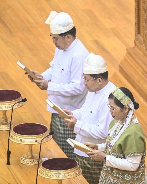 Former Myanmar military chief and Myanmar president Min Aung Hlaing (C) and vice-presidents Nyo Saw (L) and Nan Ni Ni Aye (R) attend a sworn-in ceremony during a session of the Pyidaungsu Hluttaw (Union Parliament) in Naypyidaw on April 10, 2026. Myanmar junta chief Min Aung Hlaing was sworn in as president on April 10, 2026, AFP journalists saw, continuing his rule from a civilian post five years after snatching power in a coup. (Photo by Sai Aung MAIN / AFP)
