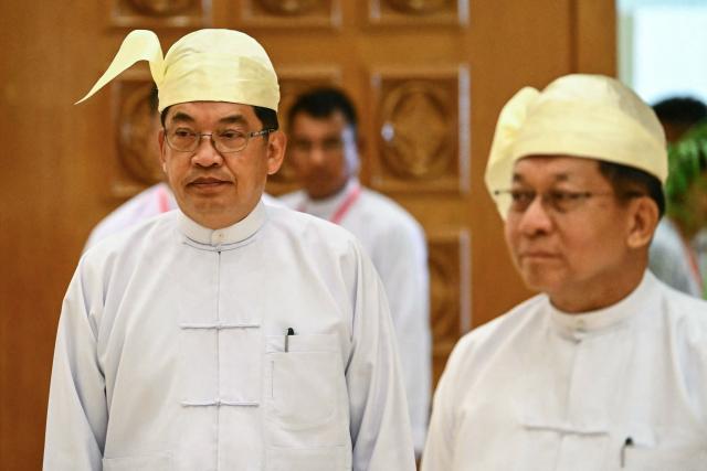 Former general and vice president Nyo Saw (L) and former Myanmar military chief and Myanmar president Min Aung Hlaing (R) arrive to attend their sworn-in ceremony during a session of the Pyidaungsu Hluttaw (Union Parliament) in Naypyidaw on April 10, 2026. Myanmar junta chief Min Aung Hlaing was sworn in as president on April 10, 2026, AFP journalists saw, continuing his rule from a civilian post five years after snatching power in a coup. (Photo by Sai Aung MAIN / AFP)