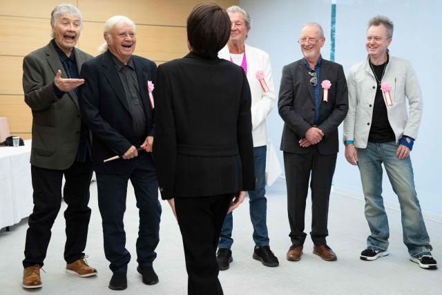 Japan’s Prime Minister Sanae Takaichi (front) greets members of British rock band Deep Purple (back L-R) Don Airey, Ian Paice, Ian Gillan, Roger Glover and Simon McBride during their meeting at the Prime Minister’s Office in Tokyo on April 10, 2026. (Photo by Yuichi YAMAZAKI / POOL / AFP)