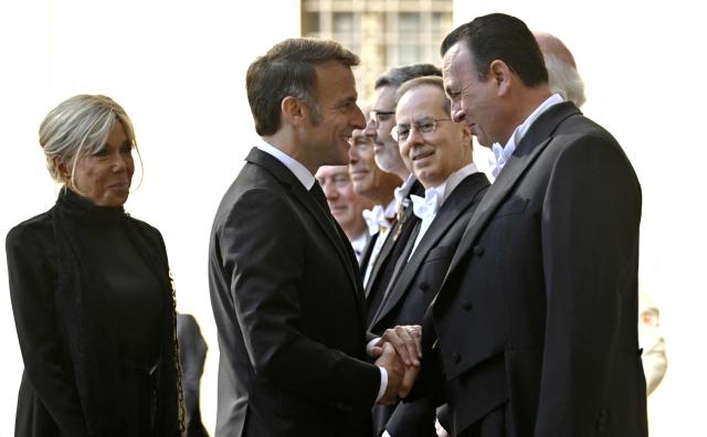 France's President Emmanuel Macron and his wife Brigitte Macron are welcomed by officials as they arrive in San Damaso courtyard before a meeting with Pope Leo XIV, in the Vatican on April 10, 2026. (Photo by Tiziana FABI / AFP)