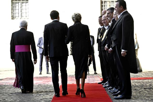 France's President Emmanuel Macron and his wife Brigitte Macron arrive in San Damaso courtyard for a meeting with Pope Leo XIV, in the Vatican on April 10, 2026. (Photo by Tiziana FABI / AFP)