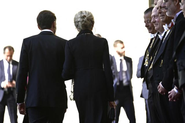 France's President Emmanuel Macron and his wife Brigitte Macron arrive in San Damaso courtyard for a meeting with Pope Leo XIV, in the Vatican on April 10, 2026. (Photo by Tiziana FABI / AFP)
