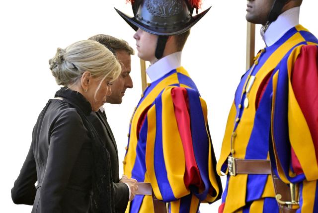 TOPSHOT - France's President Emmanuel Macron and his wife Brigitte Macron arrive in San Damaso courtyard for a meeting with Pope Leo XIV, in the Vatican on April 10, 2026. (Photo by Tiziana FABI / AFP)