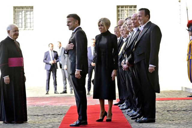 France's President Emmanuel Macron and his wife Brigitte Macron are welcomed by the regent of the Papal Household Leonardo Sapienza (L) as they arrive in San Damaso courtyard before a meeting with Pope Leo XIV, in the Vatican on April 10, 2026. (Photo by Tiziana FABI / AFP)