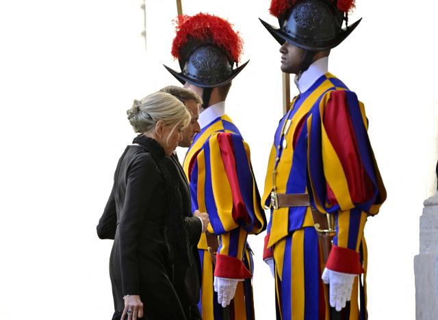 France's President Emmanuel Macron and his wife Brigitte Macron arrive in San Damaso courtyard for a meeting with Pope Leo XIV, in the Vatican on April 10, 2026. (Photo by Tiziana FABI / AFP)