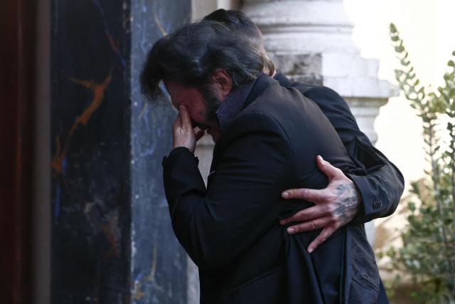 French singer, performer and Elvis Presley look-alike Eryl Prayer is comforted as he arrives to attend the funeral ceremony of Loana Petrucciani, the first reality TV star in France, at the cathedral of Sainte-Reparate in Nice, southeastern France where she was found dead at her home at the age of 48, on April 10, 2026. (Photo by Thibaud MORITZ / AFP)