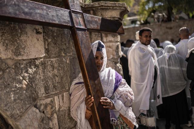 An Ethiopian Orthodox Christian follower stands next to a cross during the Good Friday procession in the Old City of Jerusalem on April 10, 2026. Christian pilgrims take part in processions along the route where according to tradition Jesus Christ carried the cross during his last days. (Photo by JOHN WESSELS / AFP)
