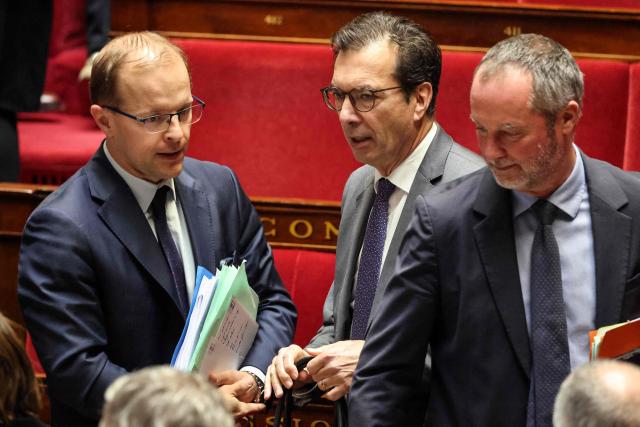 Droite Republicaine's MP Thibault Bazin (L) speaks with France's Labour Minister Jean-Pierre Farandou during a debate at the National Assembly, French Parliament lower house, to discuss a proposed low aiming to authorise the work of employees of certain businesses on May 1st, in Paris on April 10, 2026. (Photo by Ludovic MARIN / AFP)