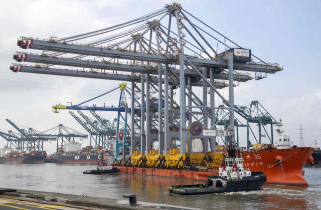 (FILES) This photograph shows a ship arriving with three new ship-to-shore cranes of DP World  during a press event in a harbour in Antwerp, on April 8, 2023. An oil spill during a ship refuelling operation has halted most traffic in Belgium's port of Antwerp, Europe's second-busiest for cargo shipping, the port said on April 10, 2026. (Photo by NICOLAS MAETERLINCK / Belga / AFP) / Belgium OUT