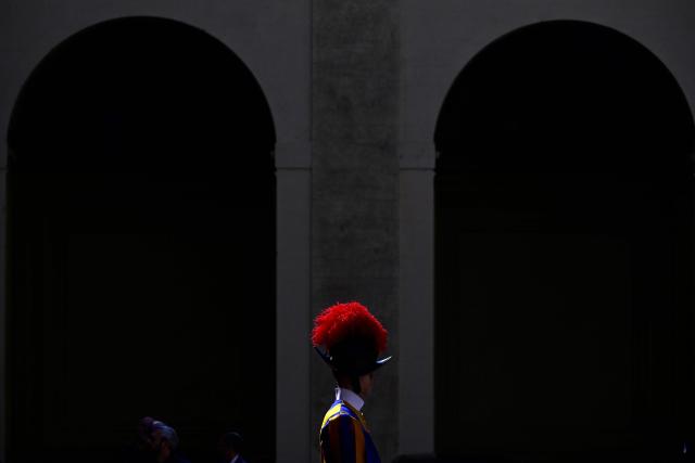 A Swiss Guard stands in San Damaso courtyard as France's President Emmanuel Macron and his wife Brigitte Macron attend a meeting with Pope Leo XIV, in the Vatican on April 10, 2026. (Photo by Tiziana FABI / AFP)
