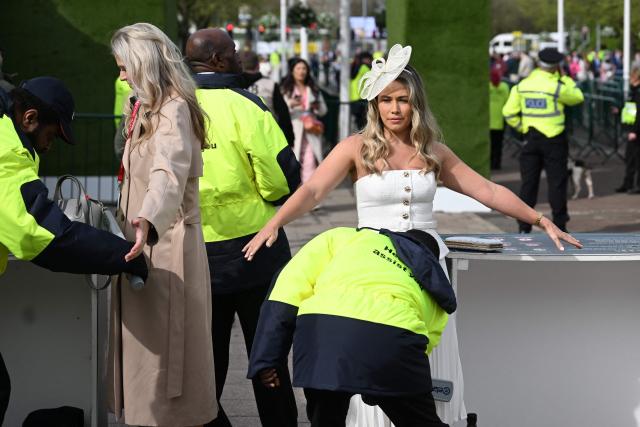 Racegoers pass through security checks as they arrive on Ladies Day, day two of the Grand National Festival horse race meeting at Aintree Racecourse in Liverpool, north-west England, on April 10, 2026. (Photo by Paul ELLIS / AFP)
