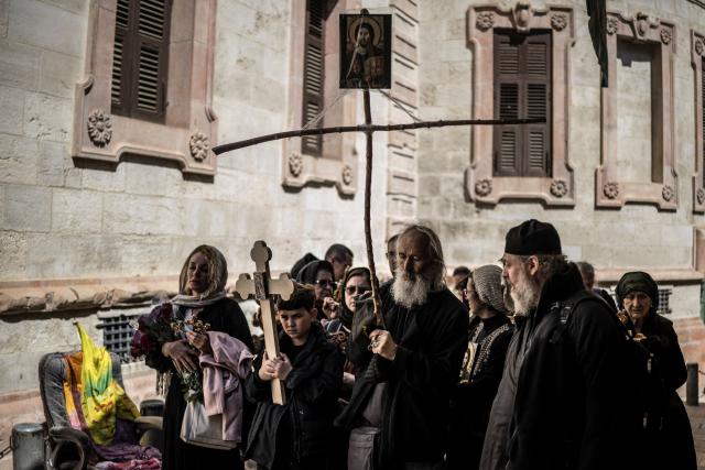 A group of Orthodox Christians pilgrims walk  in Jerusalem’s Old City during the Good Friday Procession, on April 10, 2026. Christian pilgrims are in the Holy City to mark Good Friday and pray along the traditional route Jesus Christ took to his crucifixion, leading up to his resurrection on Easter Sunday. (Photo by MARCO LONGARI / AFP)