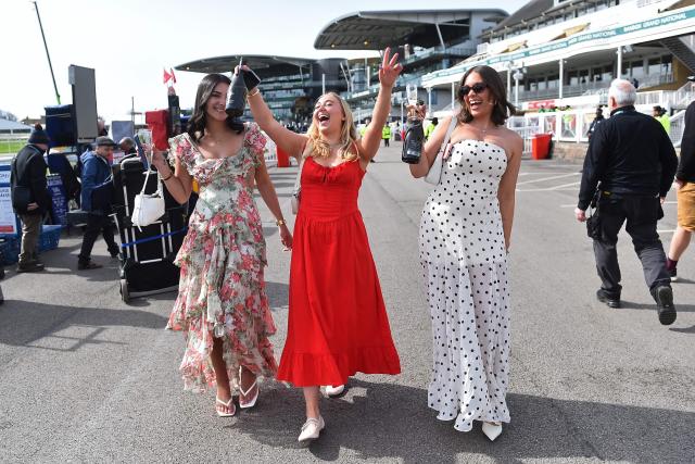 Racegoers enjoy themselves in the sunshine on Ladies Day, day two of the Grand National Festival horse race meeting at Aintree Racecourse in Liverpool, north-west England, on April 10, 2026. (Photo by PETER POWELL / AFP)