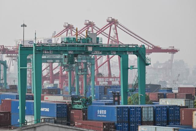 General view shows containers stacked up at Jun Gong Road container terminal in Shanghai on April 10, 2026. (Photo by HECTOR RETAMAL / AFP)