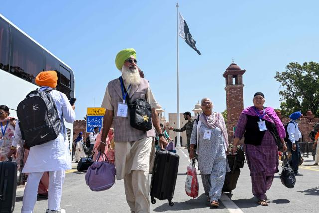 Indian Sikh pilgrims arrive to celebrate Baisakhi, the annual spring harvest festival in Pakistan, after crossing the India-Pakistan Wagah border on April 10, 2026. (Photo by Arif ALI / AFP)